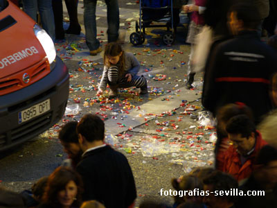 Niña cogiendo caramelos en la Cabalgata de Reyes de Sevilla