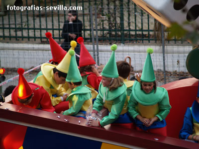 Niños lanzando caramelos desde la carroza del parchís, Cabalgata de los Reyes Magos de Sevilla