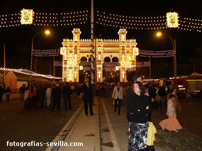 Vista nocturna de la Feria de abril de Sevilla con la Portada al fondo