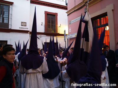 Nazarenos por las calles estrechas del centro de Sevilla en Semana Santa